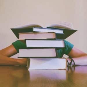 persoon verstopt zich achter boeken
