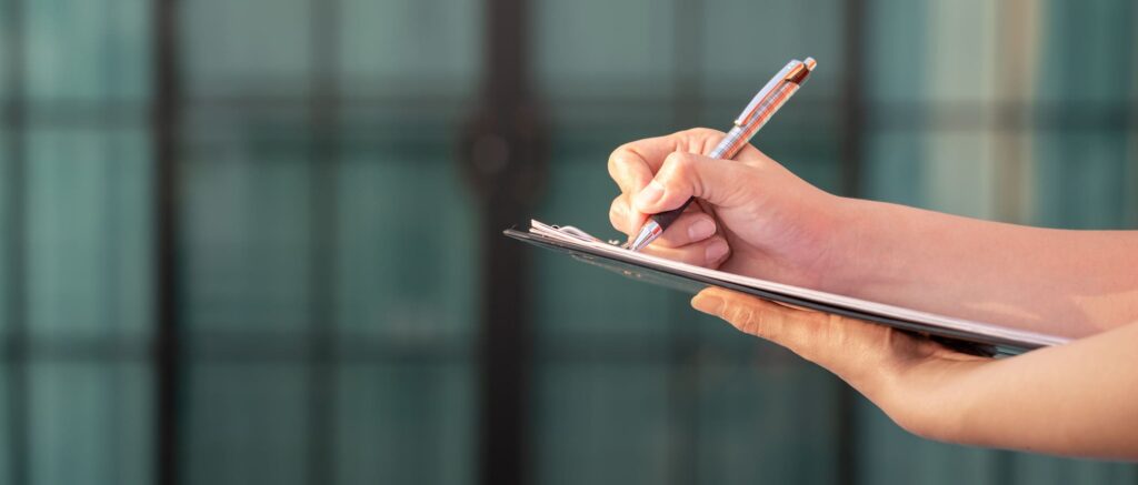 Persoon schrijft op notitieblok