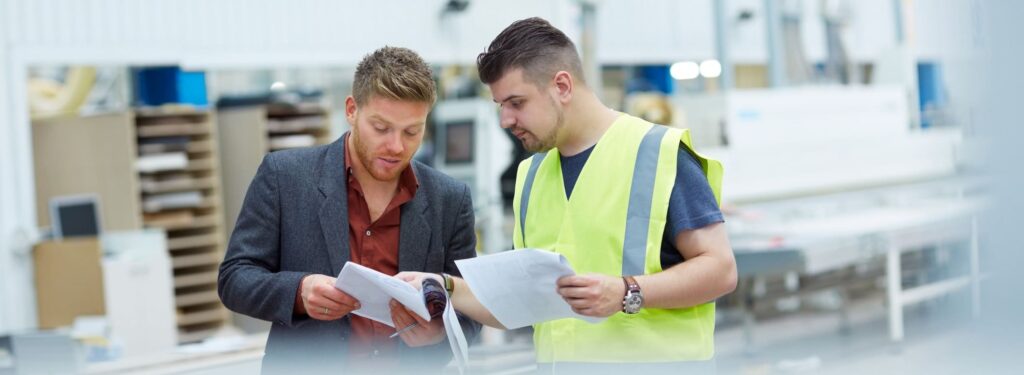 manager en medewerker bekijken een rapport in een fabriek